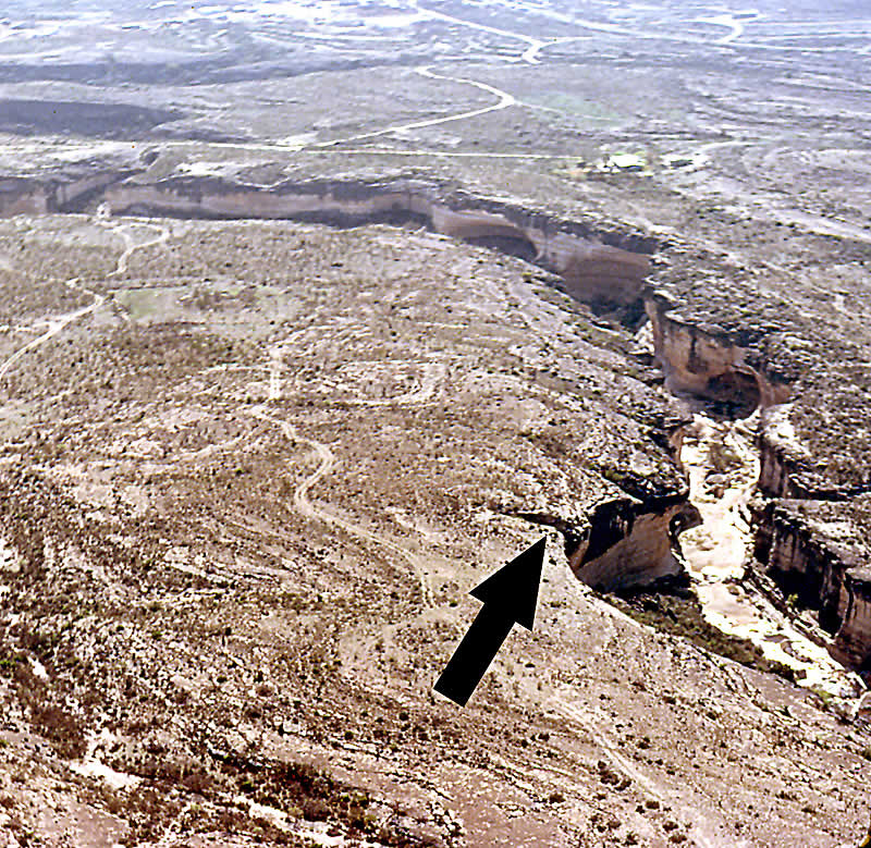 Aerial photograph of Mile Canyon. The black arrow points to the spot where bison were driven over the cliff above Bonfire Shelter. Photo by Dave Dibble.