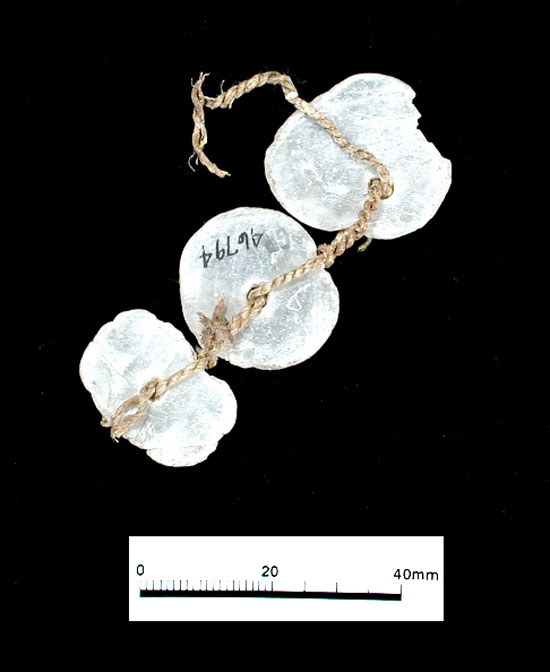 Ultra-thin discs of gypsum were drilled with holes, and suspended on fine yucca fiber cords as necklaces or other ornaments.