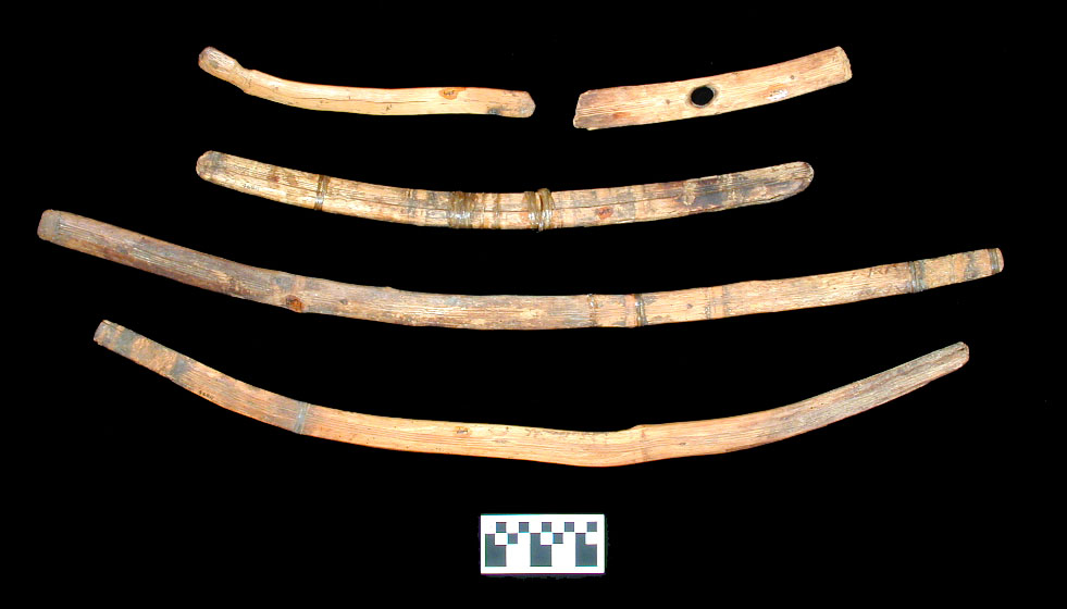 Closeup of one of several curved wood throwing and fending sticks. The throwing stick, or rabbit stick, was used to fell small game; in concept, they are not unlike the Australian boomerang although the rabbit sticks do not return to the sender. Fending sticks were used to ward off blows. The specimens shown could have been used for both purposes, although the one shown at top right has been made into a wrench used for straightening spear or dart shafts. The bottom two specimens are unusually large for rabbit sticks.