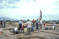 Ken Keller, one of the school's photographers, perches on a ladder to record the excavation of Room 7.