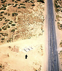 Aerial view of Firecracker Pueblo taken in 1980 after the first rooms of the pueblo were exposed. Across Highway 54 is an abandoned fireworks stand that gave the site its name.
