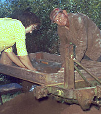 An unidentified woman and Loyd Harper work over improvised screen stand.
