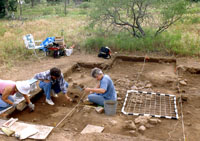 Excavation in progress. Metal grid on right side of unit was used to facilitate mapping of the excavated surfaces. Photo by Chuck Hixson.