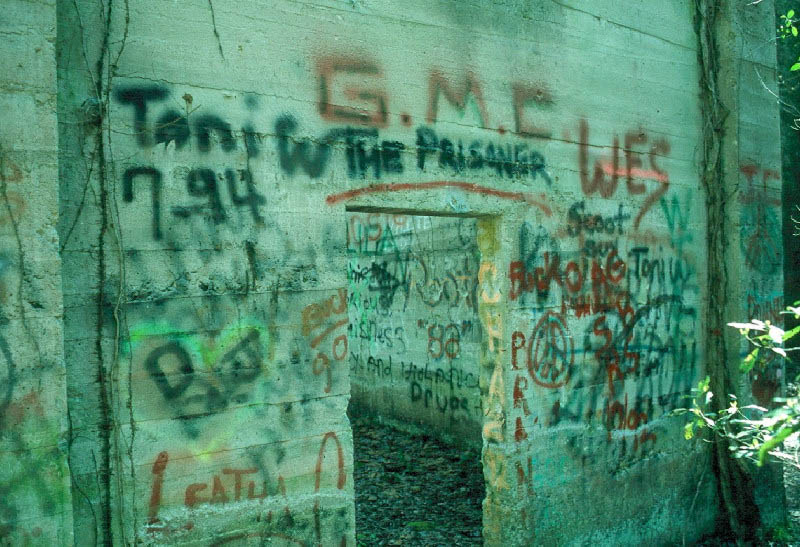photograph of a cement building with spray painted grafitti all over it