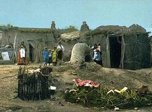 photo of mud-plastered jacal structures and outdoor ovens in the early 1900s
