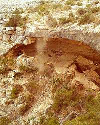 A plume of dust rises from Baker Cave, the tell-tale sign of archeologists at work. Photo of 1984 work by UT San Antonio archeologists, from TARL archives.