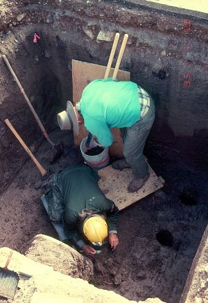 Photo of two men collecting C14 sample from an excavation