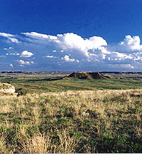 Landscape photo showing a small mesa within a broad valley.
