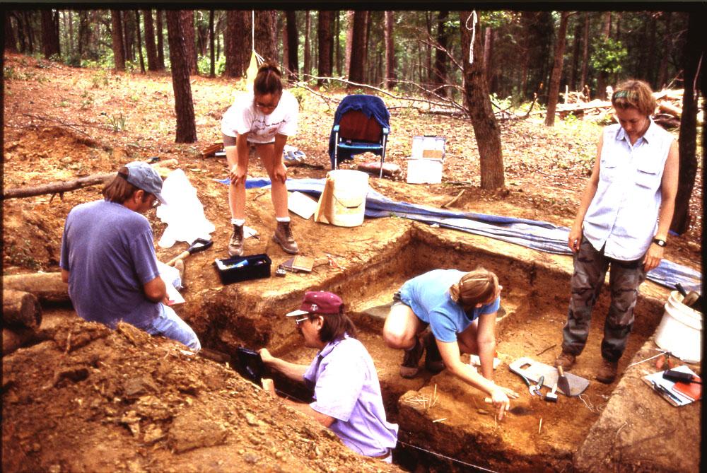 photograph of 5 people excavating a site