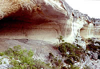 rockshelter containing grey mounds of debris