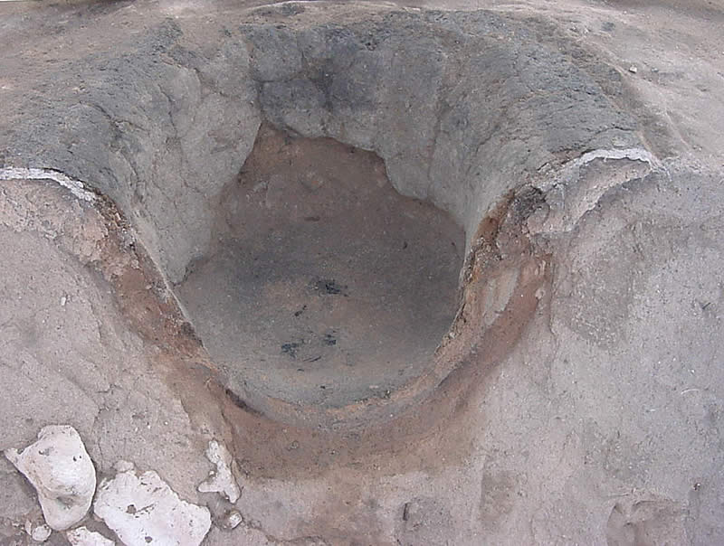 photograph of a cut in half concave hearth feature in the ground