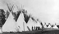 black and white photo of tipis in a row