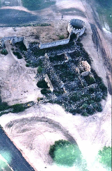 Aerial photograph of ruins of walled structures built with rocks, which is partially standing.
