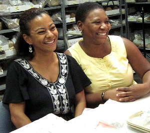 two African American women sitting in a room with shelves of artifacts