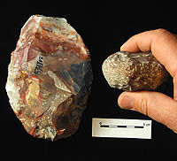 Photo of large, oval stone tool made of multi-colored flint and a small, battered hammestone.