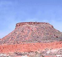 Photo of flat-topped mesa with archeologists barely visible.