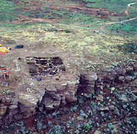 Photo of flat hill top with grid pattern of the excavations.