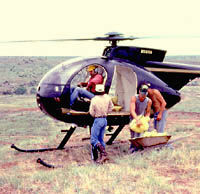 Photo of men loading bags into heliocopter.