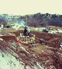 Photo showing snowy scene of excavation on creek bank.